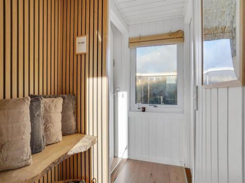a hallway with a bench and a window and a door at Holiday Home Assa - from the sea by Interhome in Hvide Sande