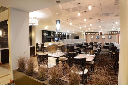 a restaurant with tables and chairs and a bar at Holiday Inn Gaithersburg by IHG in Gaithersburg