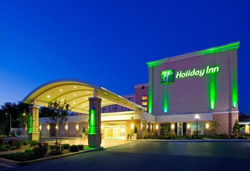 a hospital building with green lights on it at night at Holiday Inn Gaithersburg by IHG in Gaithersburg