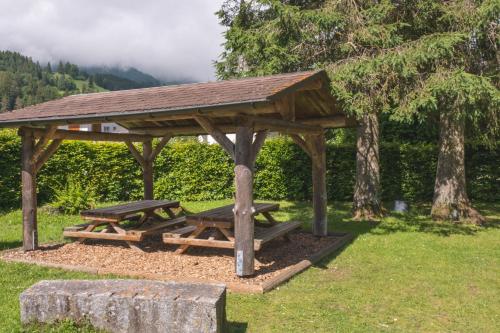 a picnic shelter with two picnic tables in a park at Engelberg Youth Hostel in Engelberg
