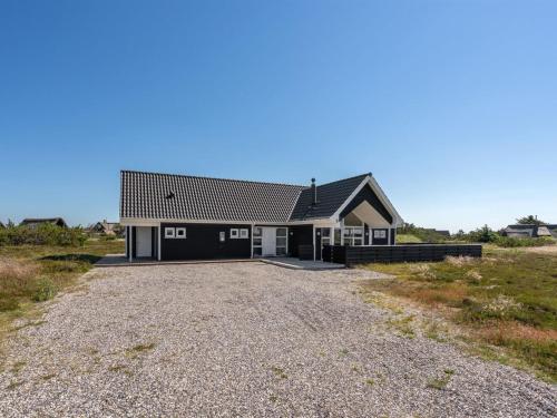ein Haus mit einer Kiesauffahrt davor in der Unterkunft Holiday Home Eliena - 500m from the sea by Interhome in Bjerregård