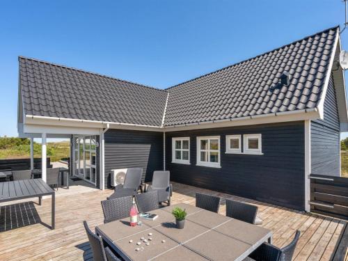 eine Terrasse mit Tisch und Stühlen auf einem Deck in der Unterkunft Holiday Home Eliena - 500m from the sea by Interhome in Bjerregård