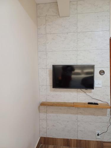 a flat screen tv mounted on a wall at Flat Cafofinho em MIGUEL PEREIRA in Miguel Pereira