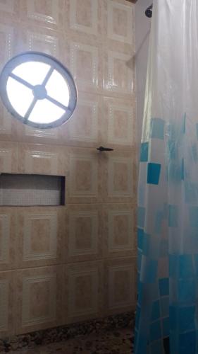 a bathroom with a shower and a door with a window at Villa Monteiro in Macaé
