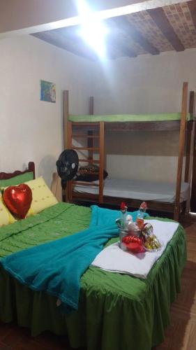 a bedroom with two bunk beds with a green bedspread at Villa Monteiro in Macaé