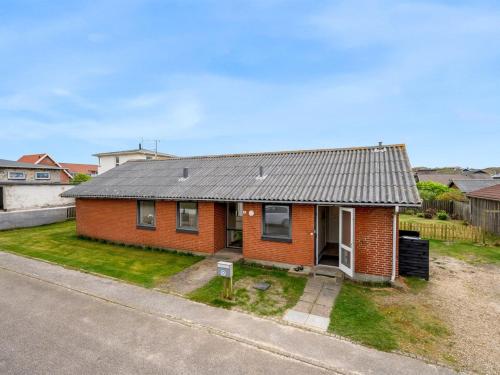 einem roten Backsteinhaus mit grauem Dach in der Unterkunft Holiday Home Agne - 400m from the sea by Interhome in Hvide Sande