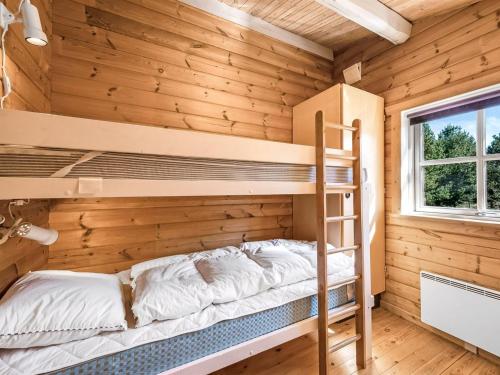 a bedroom with bunk beds in a log cabin at Holiday Home Yaris - 800m to the fjord by Interhome in Bjerregård