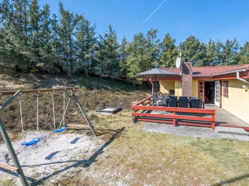 a backyard with a swing and a house at Holiday Home Yaris - 800m to the fjord by Interhome in Bjerregård