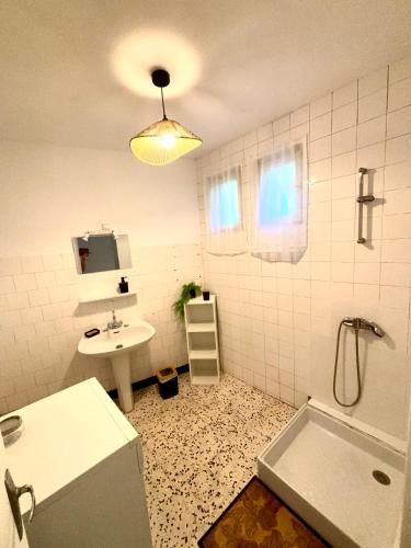 a bathroom with a sink and a toilet and a tub at Chez Mamé Marie in Fraissé-des-Corbières