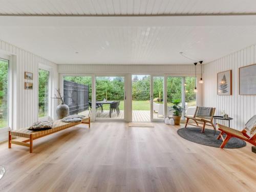 an open living room with wooden floors and glass doors at Holiday Home Doreen - from the sea by Interhome in Bjerregård