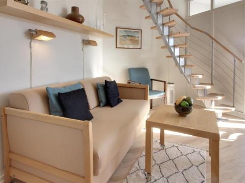 a living room with a couch and a table at Holiday Home Ena - 75m from the sea by Interhome in Lemvig