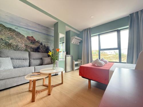 a living room with a couch and a table at Luxury Singular Pensión Estudios Blue in Santiago de Compostela