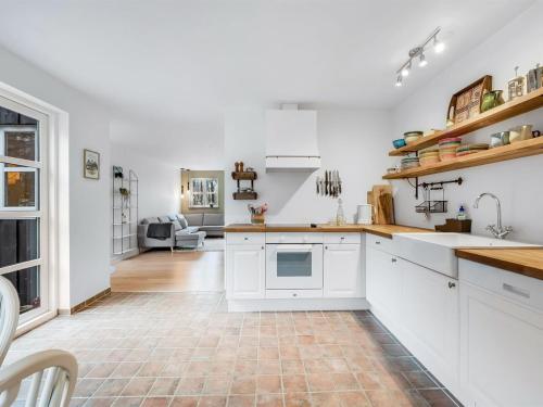 a kitchen with white cabinets and a tile floor at Holiday Home Mandana - 10km to the fjord by Interhome in Tim