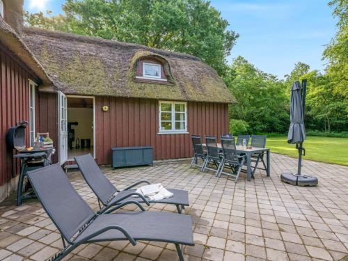 a patio with chairs and an umbrella and a table at Holiday Home Fina - 15km from the sea by Interhome in Tim
