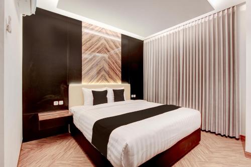 a bedroom with a large bed and a large window at Townhouse OAK Near The Park Mall Semarang Formerly Semarang Boutique Hotel in Semarang