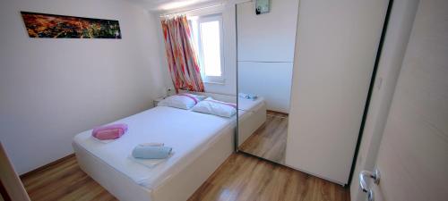a small room with a bed and a window at Apartmani ANDRIJA in Živogošće