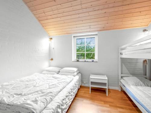 a bedroom with two beds and a window at Holiday Home Benthe - from the sea by Interhome in Ulfborg