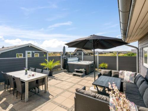 a patio with a table and an umbrella at Holiday Home Ennie - from the sea by Interhome in Bjerregård