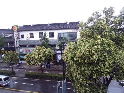 a building on a street with trees in front of it at Suzhou Blue Gate Youth Hostel in Suzhou