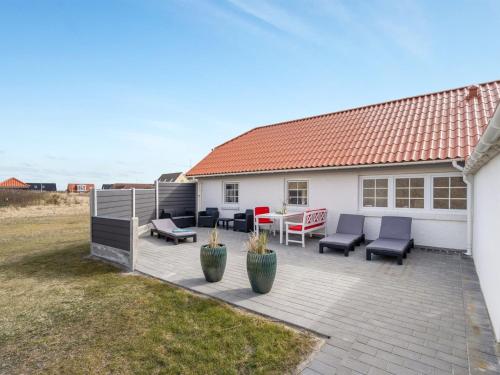 a backyard with a patio with furniture and a house at Holiday Home Pauli - 75m from the sea by Interhome in Harboør