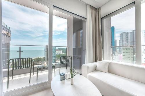 a living room with a white couch and large windows at 해운대 웨이브 Haeundae wave in Busan
