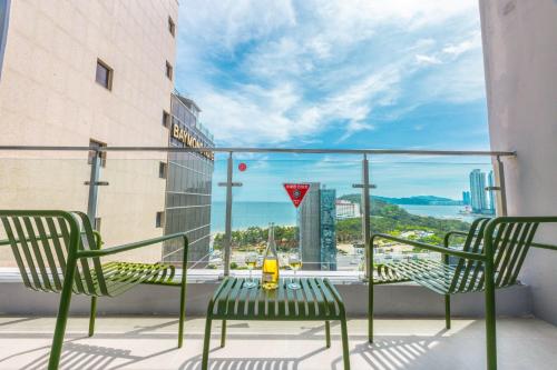 a table and chairs on a balcony with a view of the ocean at 해운대 웨이브 Haeundae wave in Busan