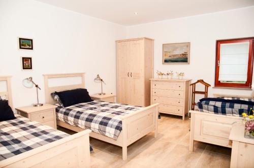 a bedroom with two beds and a dresser at Bed & Fishing House in Slap ob Idrijci