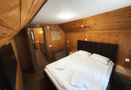 a bedroom with a large bed in a wooden room at Casa Familiei in Braşov