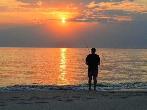 a man standing on the beach watching the sunset at Holiday Home Martinus - 5-5km from the sea by Interhome in Tim