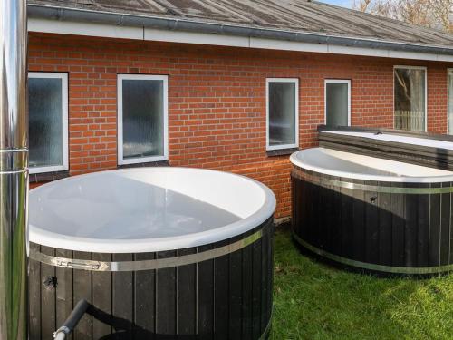two jacuzzi tubs in front of a brick building at Holiday Home Martinus - 5-5km from the sea by Interhome in Tim