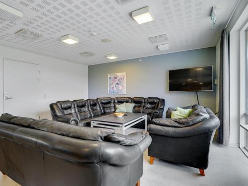a living room with leather furniture and a flat screen tv at Holiday Home Martinus - 5-5km from the sea by Interhome in Tim