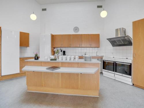 a large kitchen with wooden cabinets and appliances at Holiday Home Martinus - 5-5km from the sea by Interhome in Tim