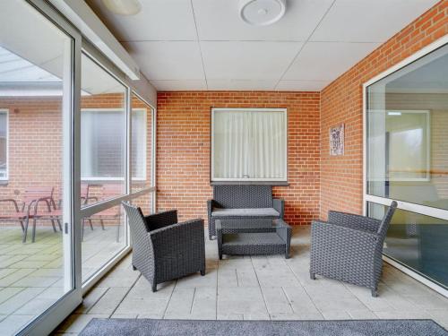 a patio with chairs and tables and a brick wall at Holiday Home Martinus - 5-5km from the sea by Interhome in Tim