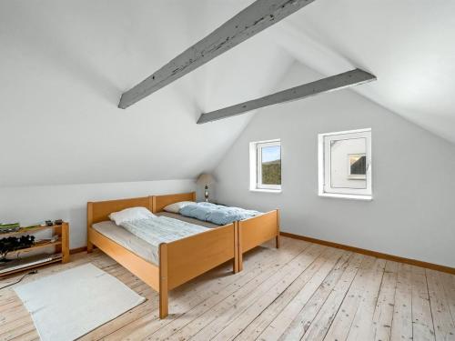 a bedroom with a bed and two windows at Holiday Home Orvo - 150m from the sea by Interhome in Harboør