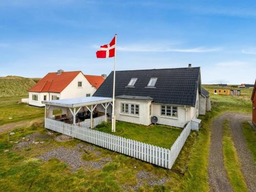 a house with a canadian flag on top of it at Holiday Home Orvo - 150m from the sea by Interhome in Harboør
