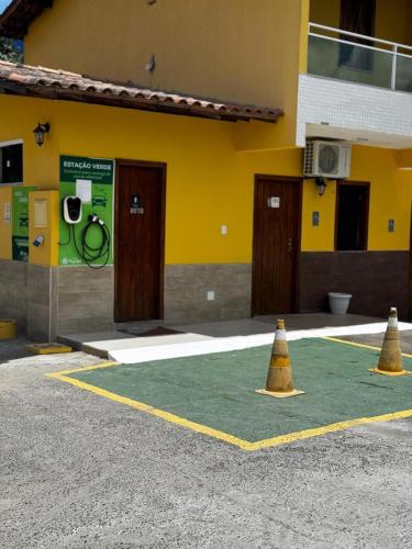 two yellow cones in front of a building at Pousada Itajuípe- Unidade Itabuna-Ba in Itabuna