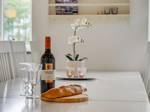 a bottle of wine and a loaf of bread on a table at Apartment Edine - 4-5km from the sea by Interhome in Ulfborg