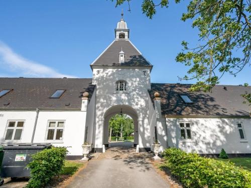 an entrance to a white building with a tower at Apartment Edine - 4-5km from the sea by Interhome in Ulfborg