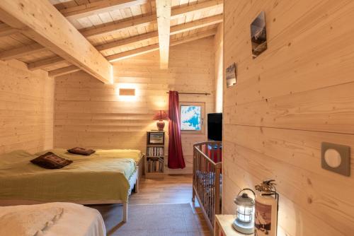 Habitación con 2 camas en una cabaña de madera en Le petit Ranch, en Le Reposoir