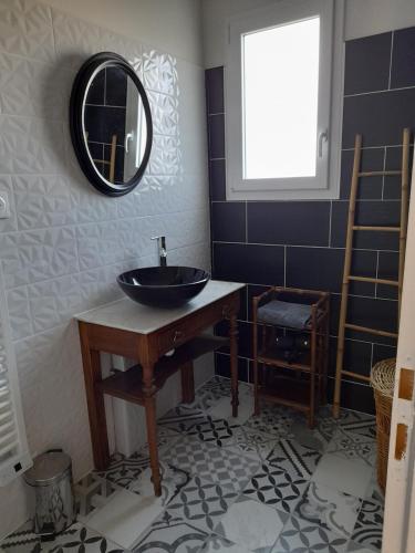 une salle de bains avec un lavabo et un miroir dans l'établissement Le rocher, à Longeville-sur-Mer