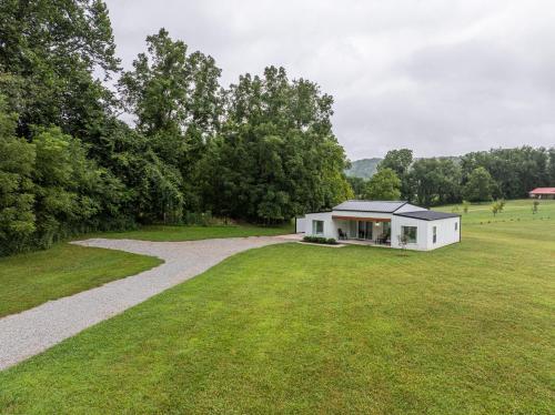 a white house in a field with a gravel driveway at Swancrest in Killbuck
