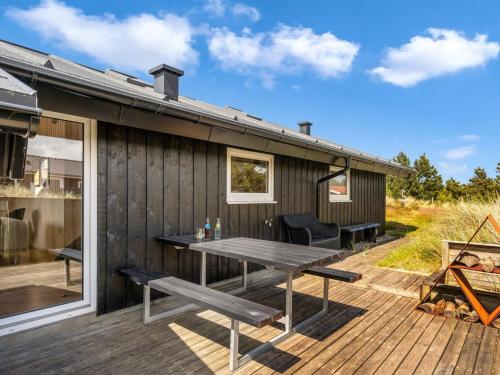 a wooden deck with a picnic table on a house at Holiday Home Suleika - 900m from the sea by Interhome in Torsted