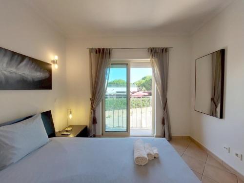 a bedroom with a large bed with towels on it at Vilapeti by SAPvillas in Vilamoura