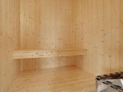 an empty sauna with a wooden shelf on the wall at Holiday Home Frido - 400m from the sea by Interhome in Torsted