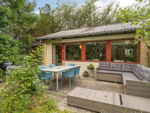 a house with a patio with a table and chairs at Holiday Home Flor - 900m from the sea by Interhome in Torsted