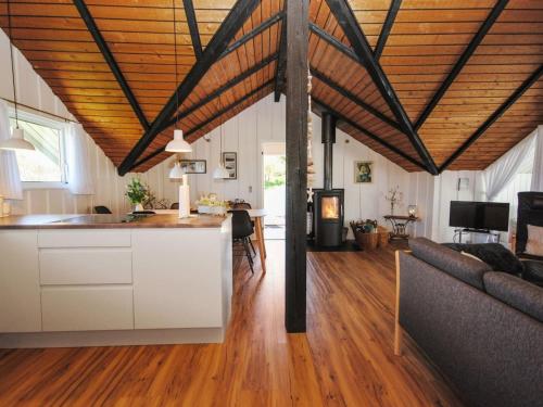 a kitchen and living room with wooden ceilings and a couch at Holiday Home Sakulf - 600m from the sea by Interhome in Torsted