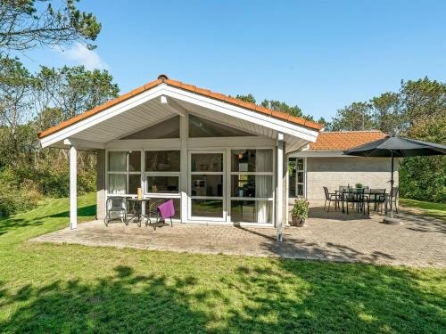 a pavilion with a table and chairs and an umbrella at Holiday Home Aslak - 350m from the sea by Interhome in Torsted