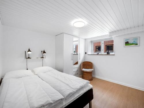 a white bedroom with a bed and a window at Holiday Home Eluisa - 300m from the sea by Interhome in Thyborøn