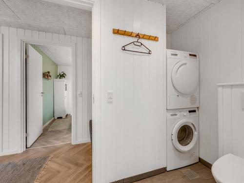 - une buanderie blanche avec lave-linge et sèche-linge dans l'établissement Holiday Home Markku - 400m from the sea by Interhome, à Harboør
