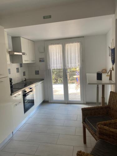 a living room with a kitchen and a table at BAS DE VILLA, Mer Piscine et SPA in Roquebrune-sur-Argens